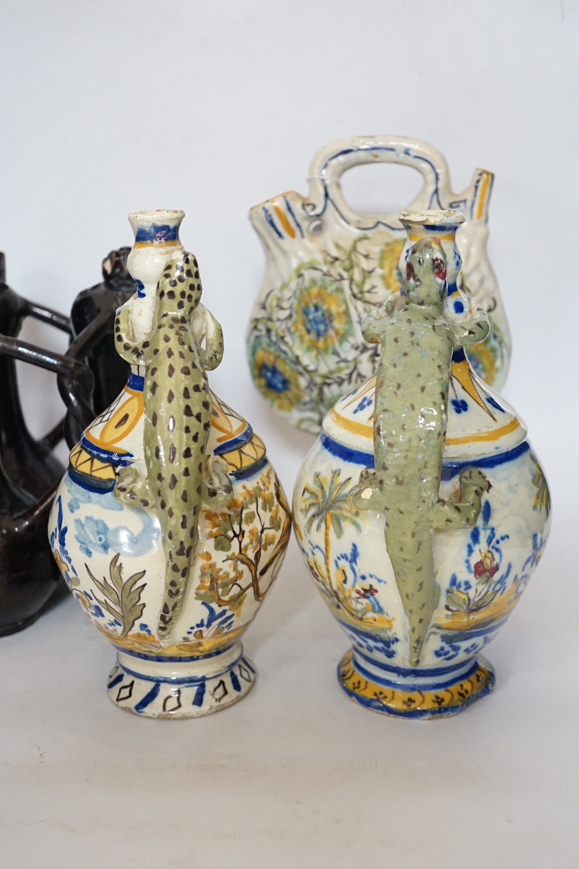 A Slavonic three section brown glazed earthenware puzzle jug and pair of 19th century Portuguese lizard handle maiolica vases and two other similar items, largest 28cm high